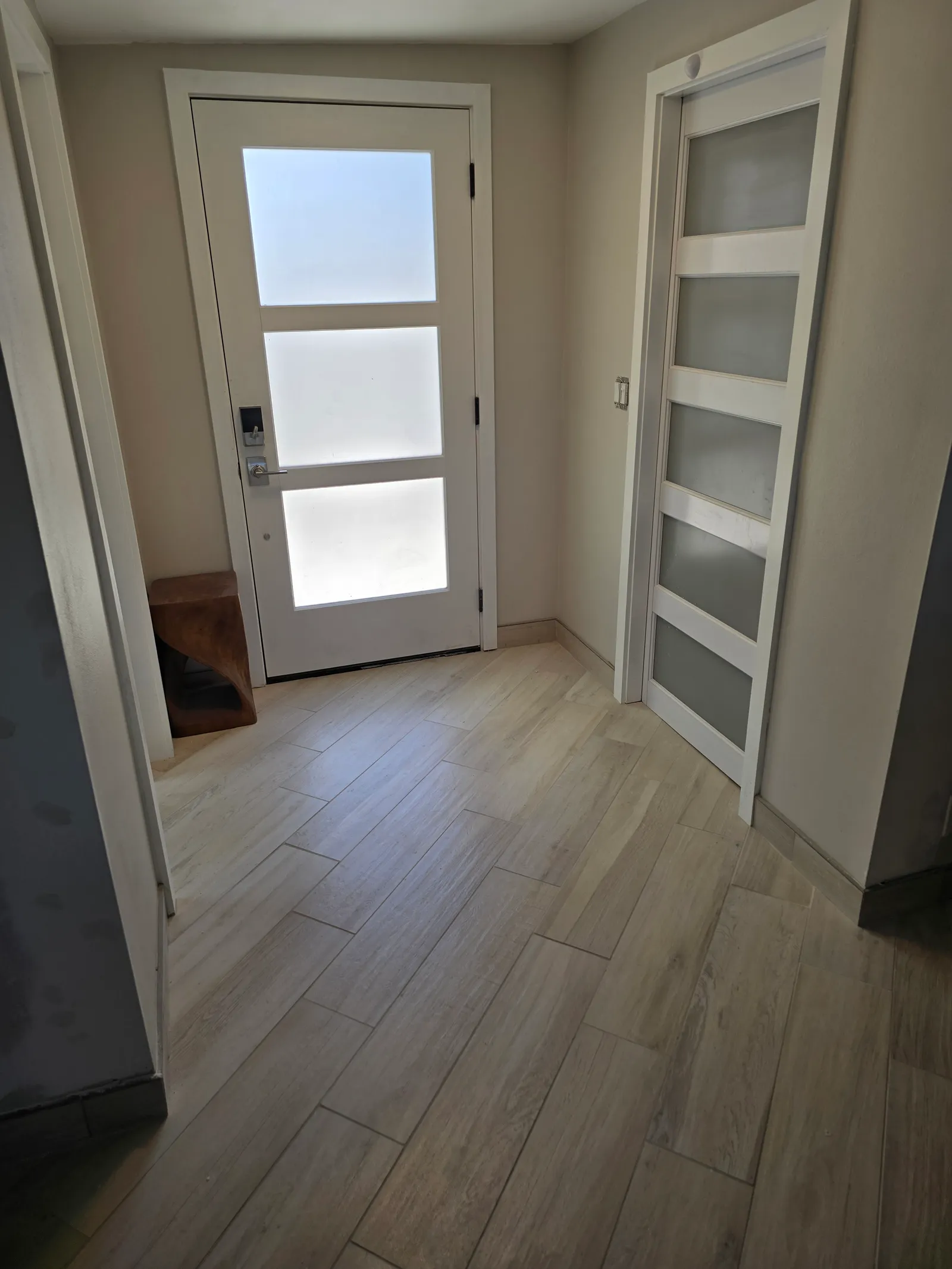 Modern entryway renovation with wood-look plank tile flooring in Maui